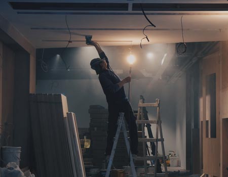 A plasterer working on a ceiling