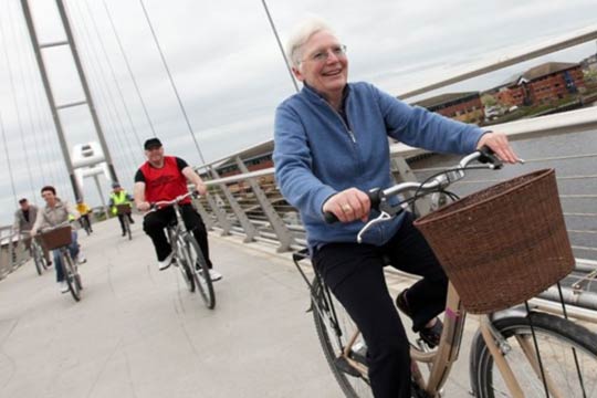 Old people cycling across a bridge